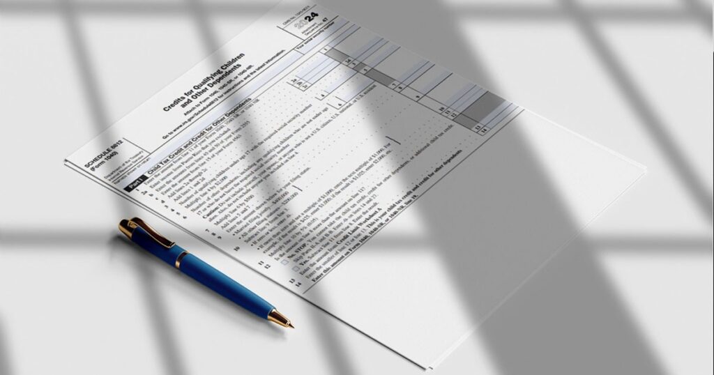 Tax forms and pen on a table, representing IRS Form 8812 and the process of understanding tax-related information.