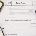 W-9 tax form with phone and calculator