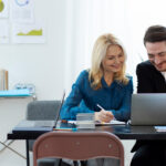 Two professionals working together on bookkeeping tasks.