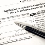 Tax extension form with pen placed on paperwork.