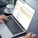 Person using a laptop to manage tax forms online.