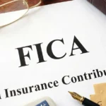 FICA document with money, pen, and office supplies on desk.