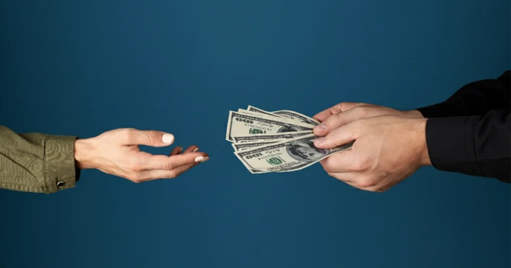 Hands exchanging cash, representing a financial transaction
