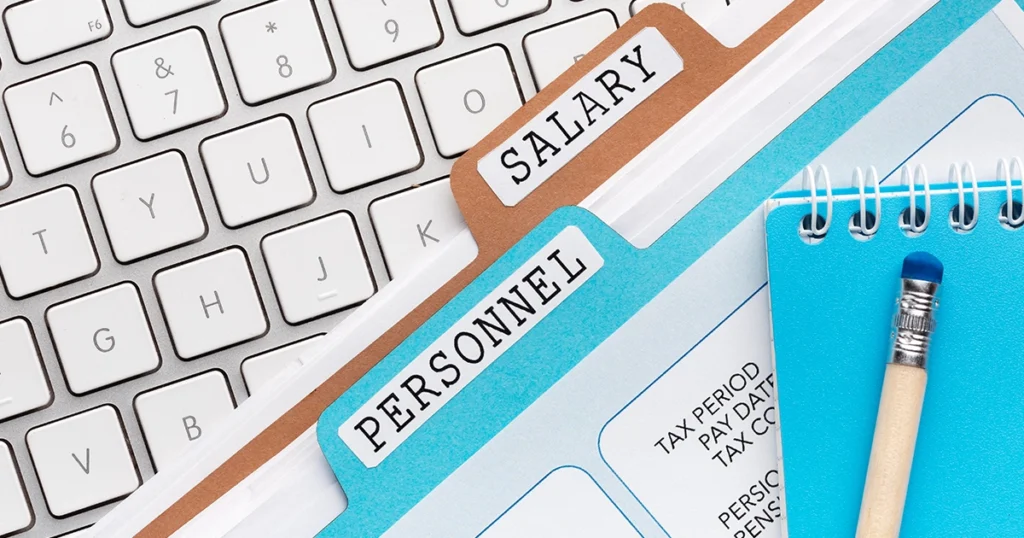 Salary and personnel files with payroll documents on desk