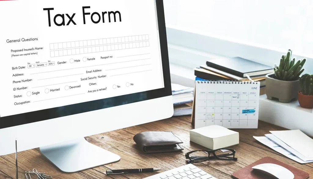 Computer monitor displaying digital tax form in wooden office.
